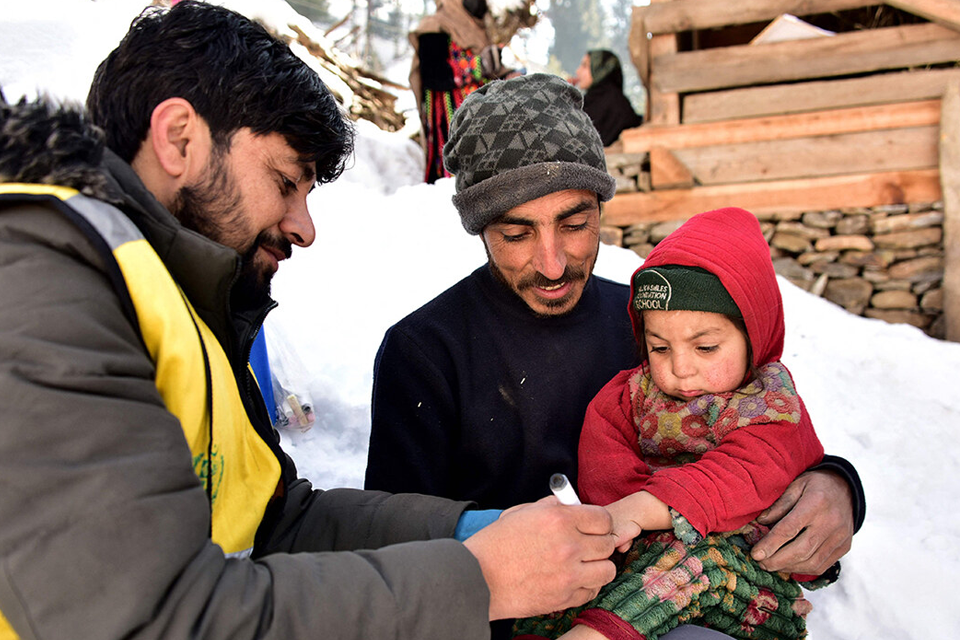 A health worker marks a child's finger after administering polio drops during a vaccination drive in Azad Jammu Kashmir's Neelum Valley on February 4, 2025. Photo: AFP